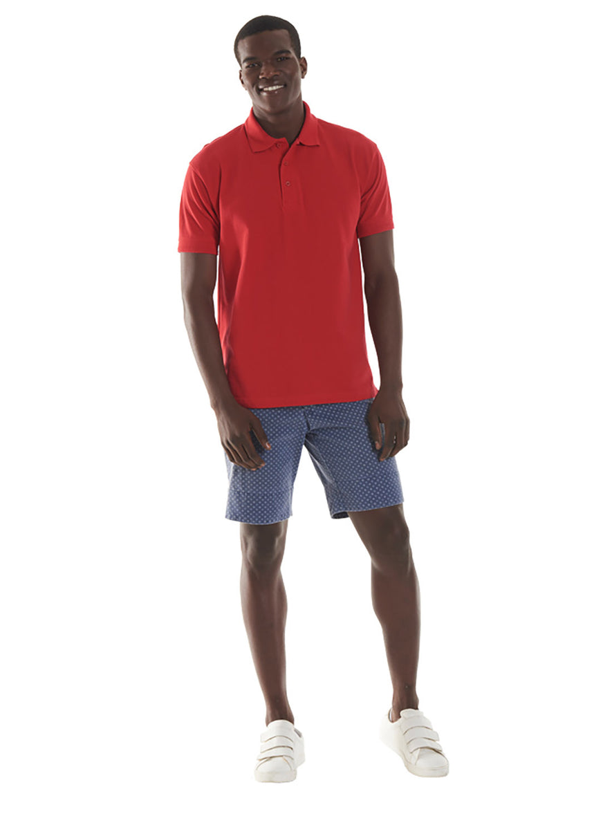 Person wearing Uneek Clothing UC104 250GSM Ultimate Poloshirt in red with short sleeves, collar and three button plackett.