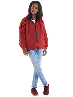 Person wearing Uneek Clothing UC606 Childrens Reversible Fleece Jacket with waterproof outside in red with navy full zip fastening and two lower pockets.