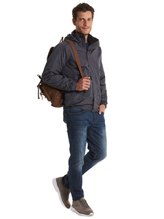 Person wearing Uneek Clothing UC620 - Premium Outdoor Jacket in deep grey with hood with black fleece lining, full front zip and flap with velcro, two front lower pockets with flap concealed zip.